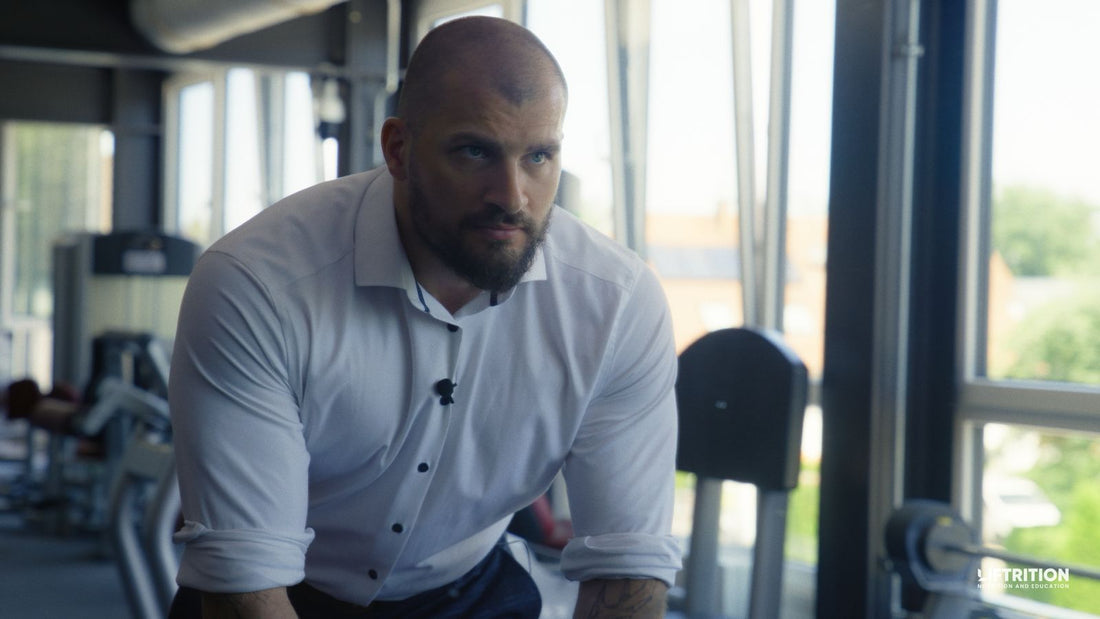 Philipp Heckenstaller im weißen Hemd an einem Kabelzuggerät im Fitnessstudio.
