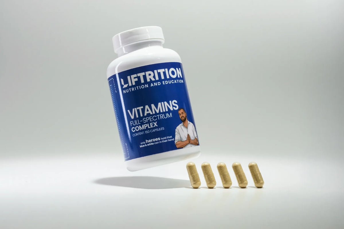Liftrition Elite Multivitamin: weiße Dose mit royalblauem Etikett vor blaugrauem Hintergrund, davor ein dichtes Feld beiger Kapseln.