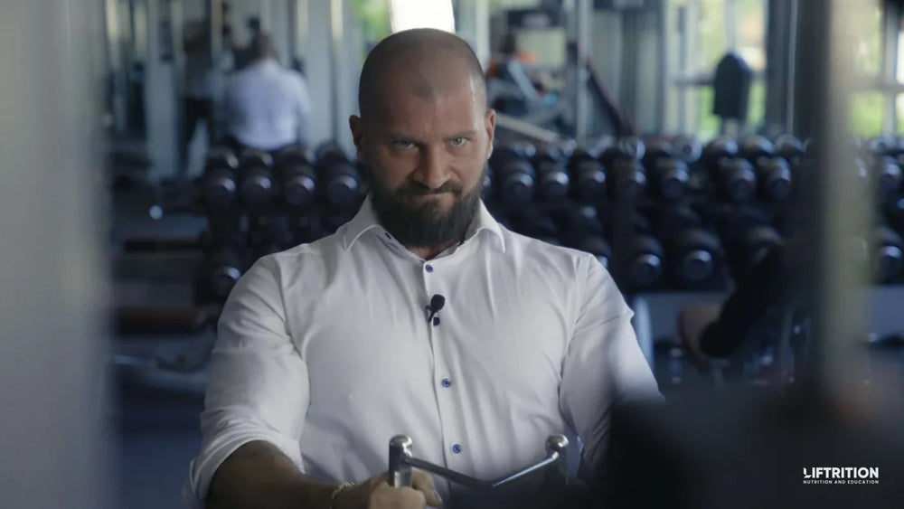 Philipp Heckenstaller im weißen Hemd an einem Kabelzuggerät im Fitnessstudio.