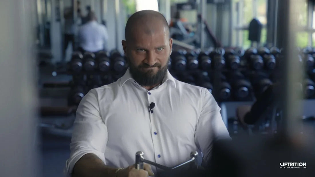 Philipp Heckenstaller im weißen Hemd an einem Kabelzuggerät im Fitnessstudio.